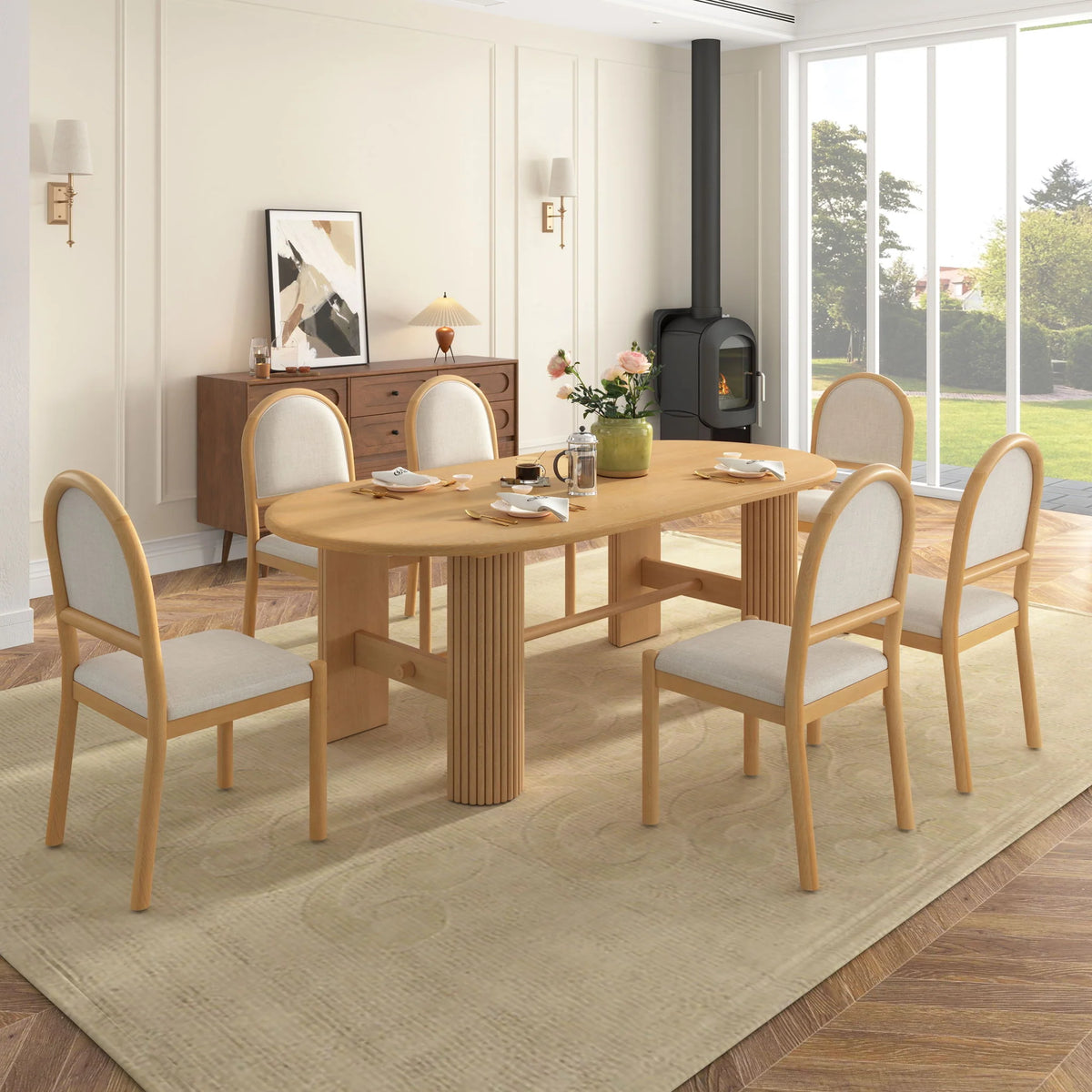 Light brown oval dining table with fluted supports and six beige upholstered round-back chairs