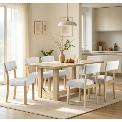 Light oak rectangular trestle table with six light upholstered chairs in a bright dining room