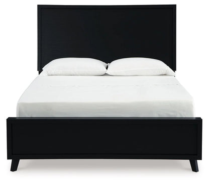 Front view of the Danziar black panel bed with white bedding