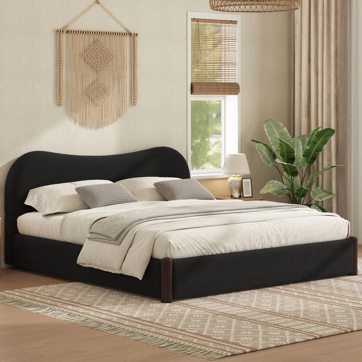 Black upholstered platform bed with a curved headboard and white bedding in a warm neutral bedroom