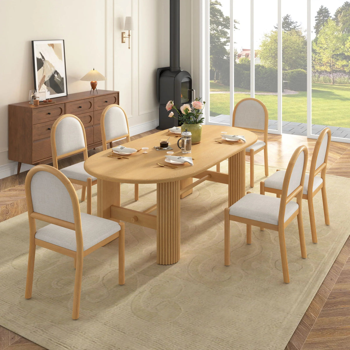 Angled overhead view of the light brown oval dining table with six beige upholstered chairs