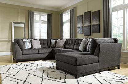 Angled living room view of the Reidshire steel gray sectional with tufted back cushions and a chaise