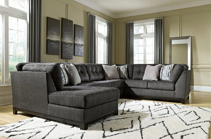 Reidshire steel gray sectional with a foreground chaise and patterned accent pillows in a living room