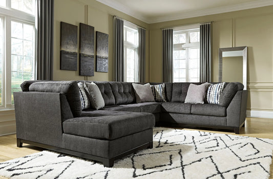Reidshire steel gray sectional with a foreground chaise and patterned accent pillows in a living room